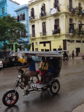 Havana pedi-cab and yellow building