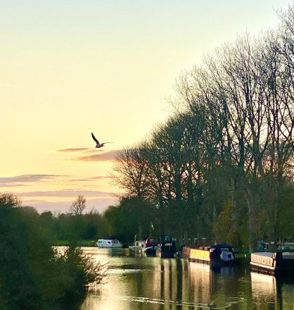 barges lining the river in Lechlade at sunset in the Cotswolds